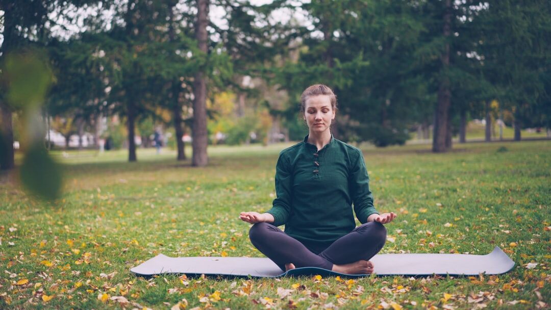 person meditating outdoors
