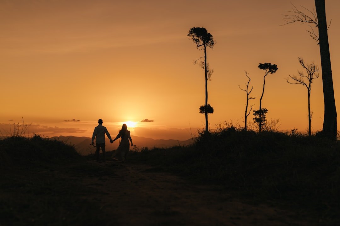 Silhouette of a couple walking on a rambla at sunset in Montevideo